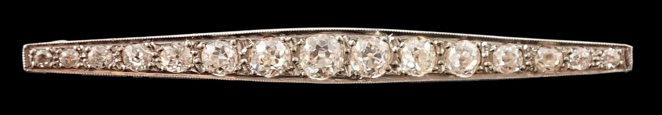 A 1920's gold, platinum and millegrain set graduated old round cut diamond bar brooch